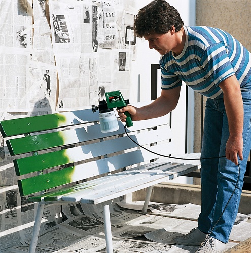  A man paints a bench sandblasted